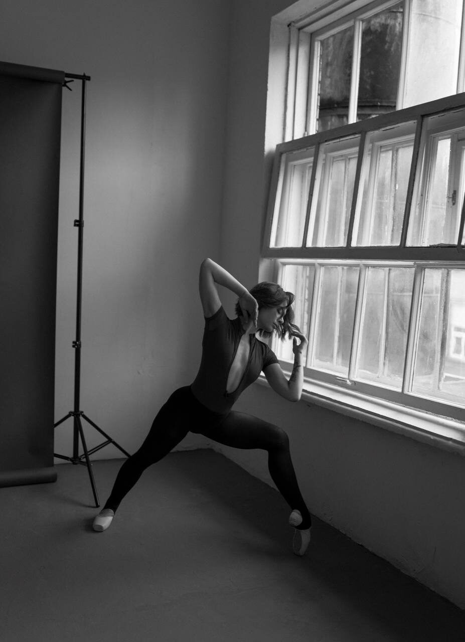 Valeriia in a deep lunge by studio window